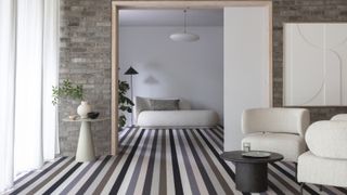 striped carpet in minimal living room with doorway and cream furniture with curved shapes