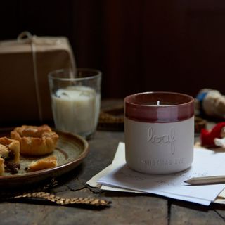 wooden table with paper and loaf candle