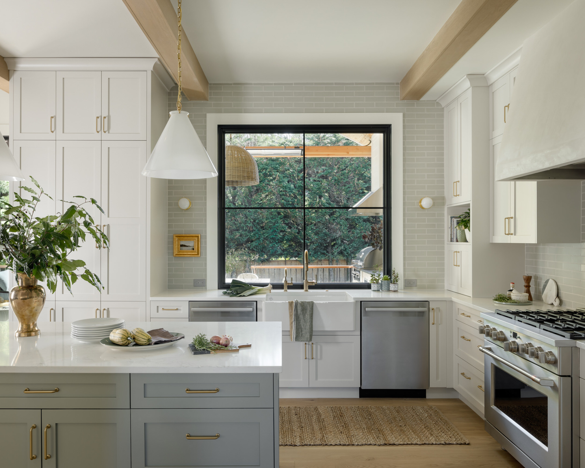 Kitchen with neutral cabinets and gray island, range and white countertops
