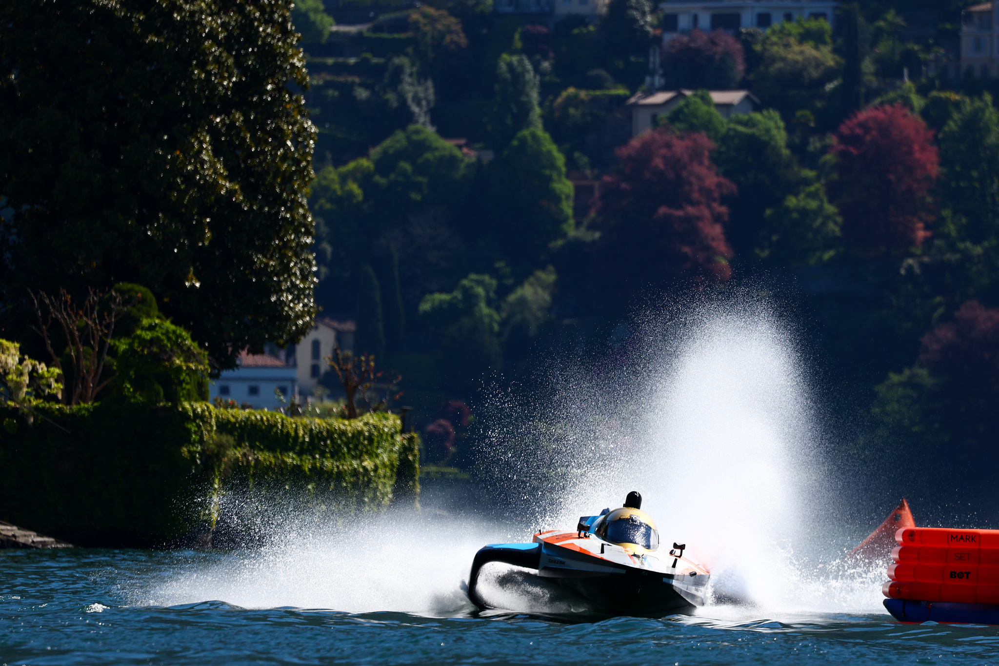 A powerboat makes a big splash going round a buoy