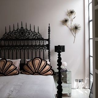 white bedroom with black ornate bed