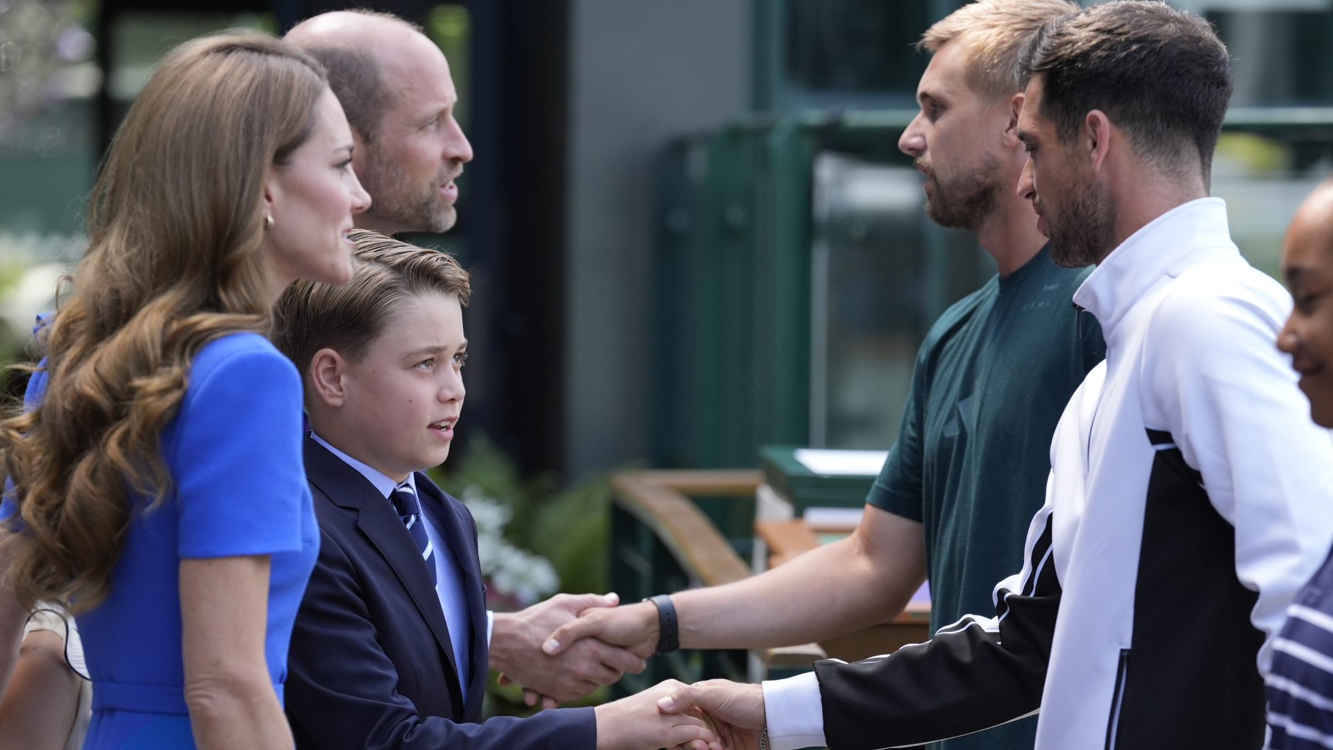 Prince George standing next to Princess Kate and Prince William, shaking hands with Julian Cash and Lloyd Glaspool at Wimbledon