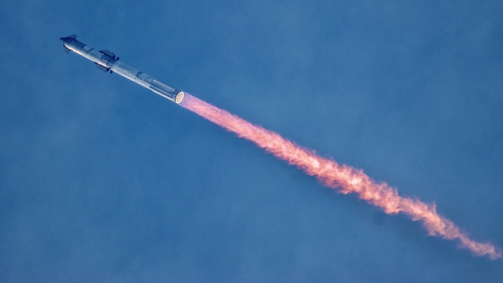 a giant rocket launches against a colorful sky