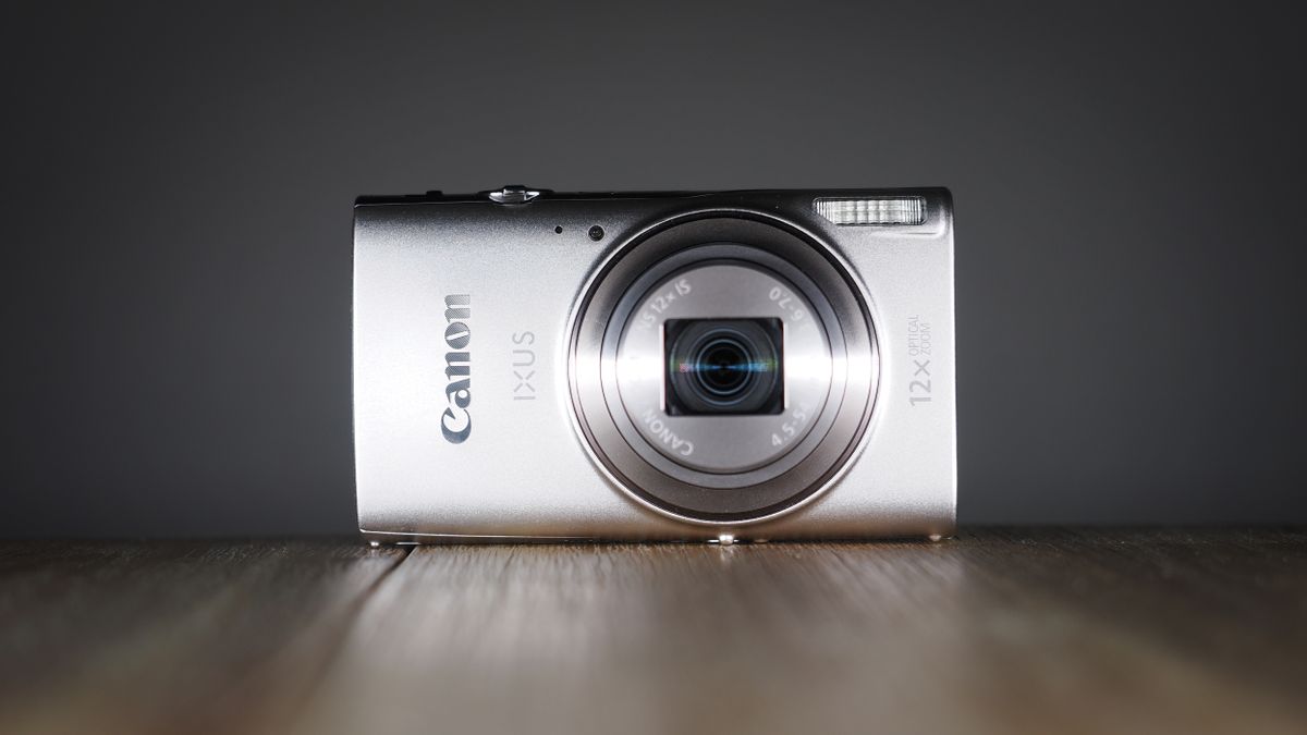Canon Ixus 285 HS A on a wooden surface against a dark background