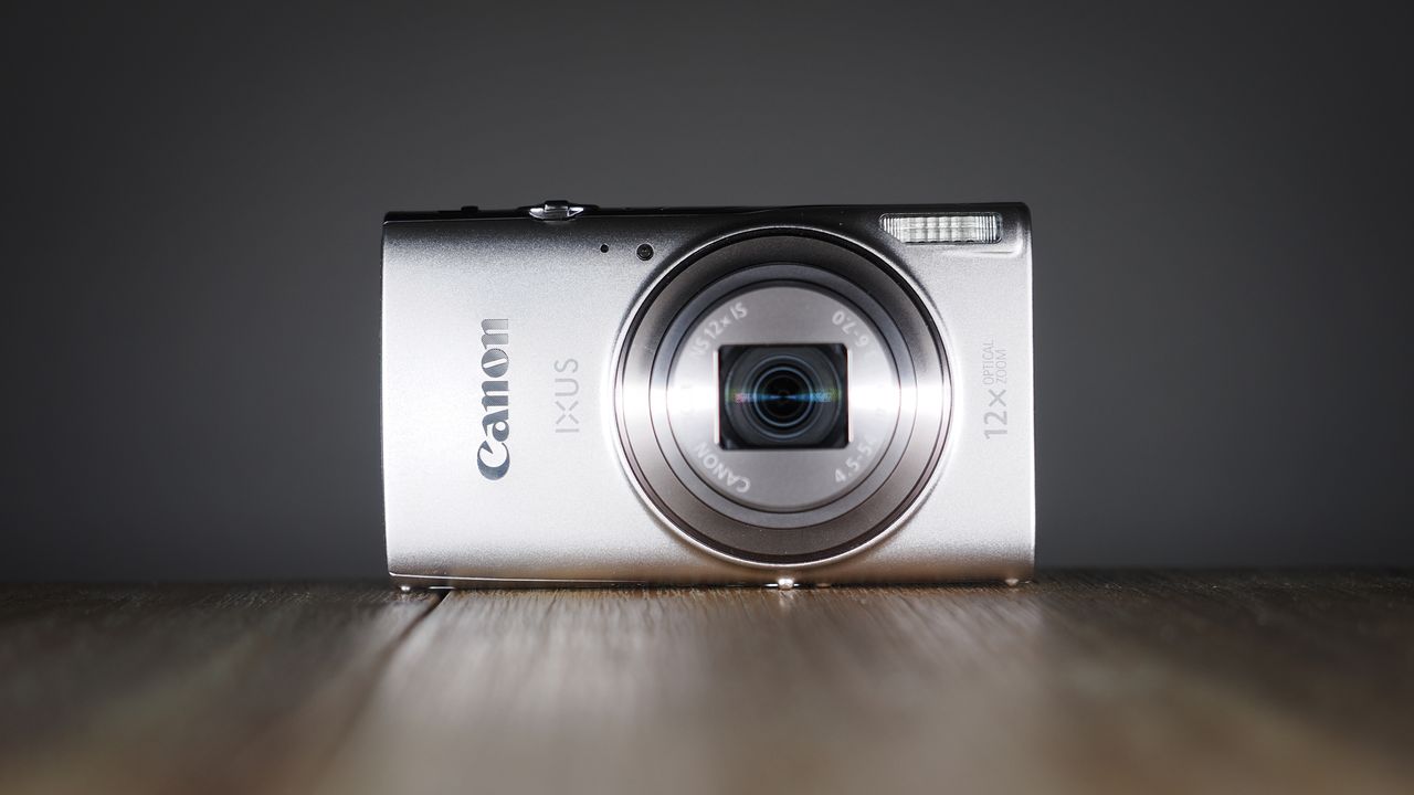 Canon Ixus 285 HS A on a wooden surface against a dark background