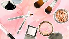 makeup products scattered on a pink marble background