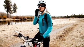 Woman stopping to eat a snack while mountain biking