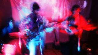 Nick Mason, Roger Waters and Syd Barrett of Pink Floyd perform under psychedelic lighting at the Architectural Association student party, London, 16th December 1966. (Photo by Adam Ritchie/Redferns)