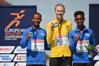 Israel's silver and bronze medallists in the men's marathon at the European Championships holding their medal, either side of the gold medal winner from Germany