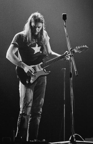 David Gilmour playing Fender Stratocaster guitar, using wah wah pedal, on stage at Shelter benefit concert on 'Dark Side Of The Moon' tour at Earls' Court, London, UK, 18th May 1973.
