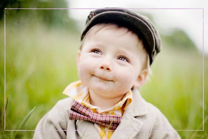 A baby wearing a flat cap and bow tie
