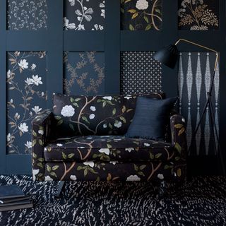 room with patterned wallpaper and black armchair