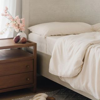 Corner of the Cozy Earth Bamboo Sheet Set beside a wood nightstand.