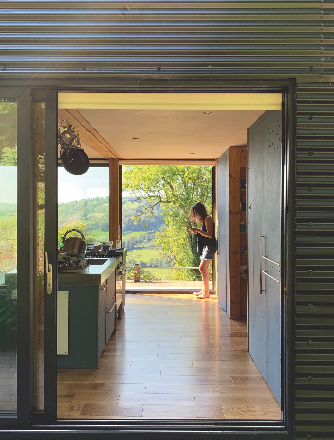 Rough and raw finishes still reign throughout the home, including bare plaster and ply timber cladding. The large sliding doors, from Smart Systems, on both sides of the house draw back to expose the main living area to the elements completely in the summer.