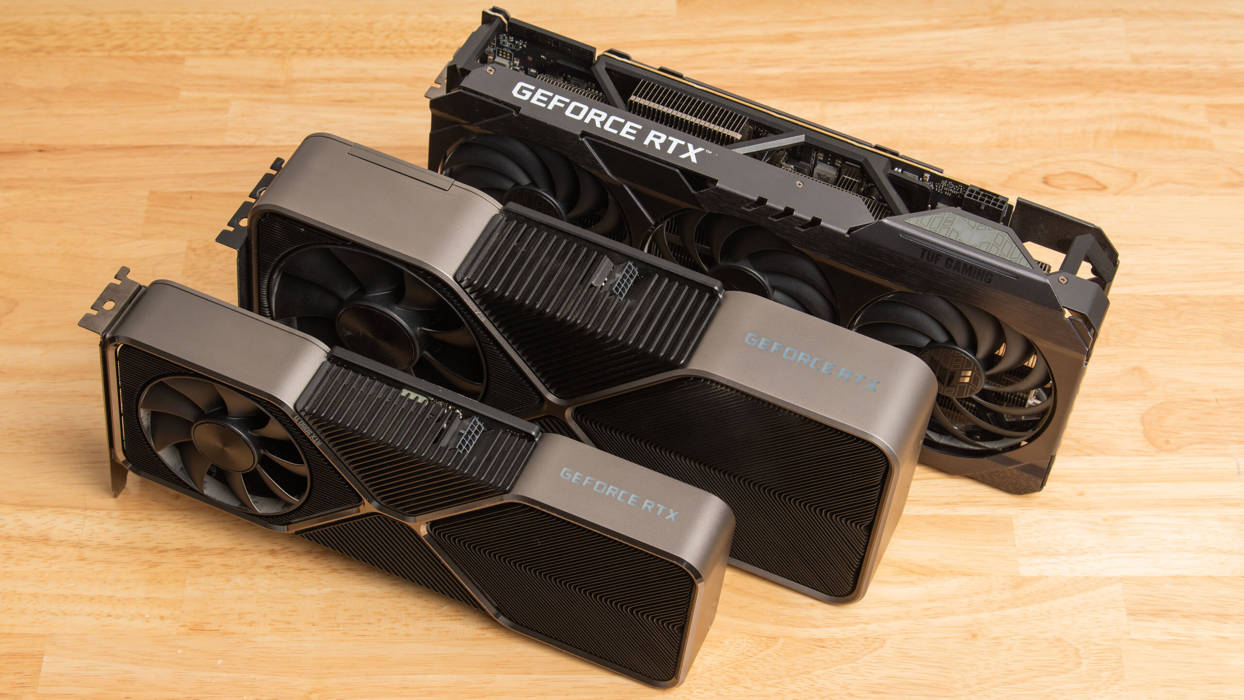 3080 Ti, 3090 and 3090 Ti GPUs on a desk.