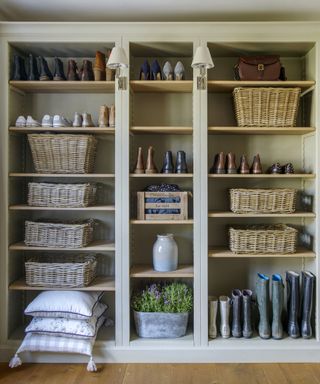 A mudroom with a full wall of open-shelving storage, organized with woven baskets