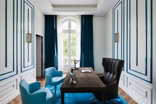 a blue and white home office with blue curtains