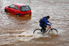 A cyclist passes a stranded car in Birmingham.