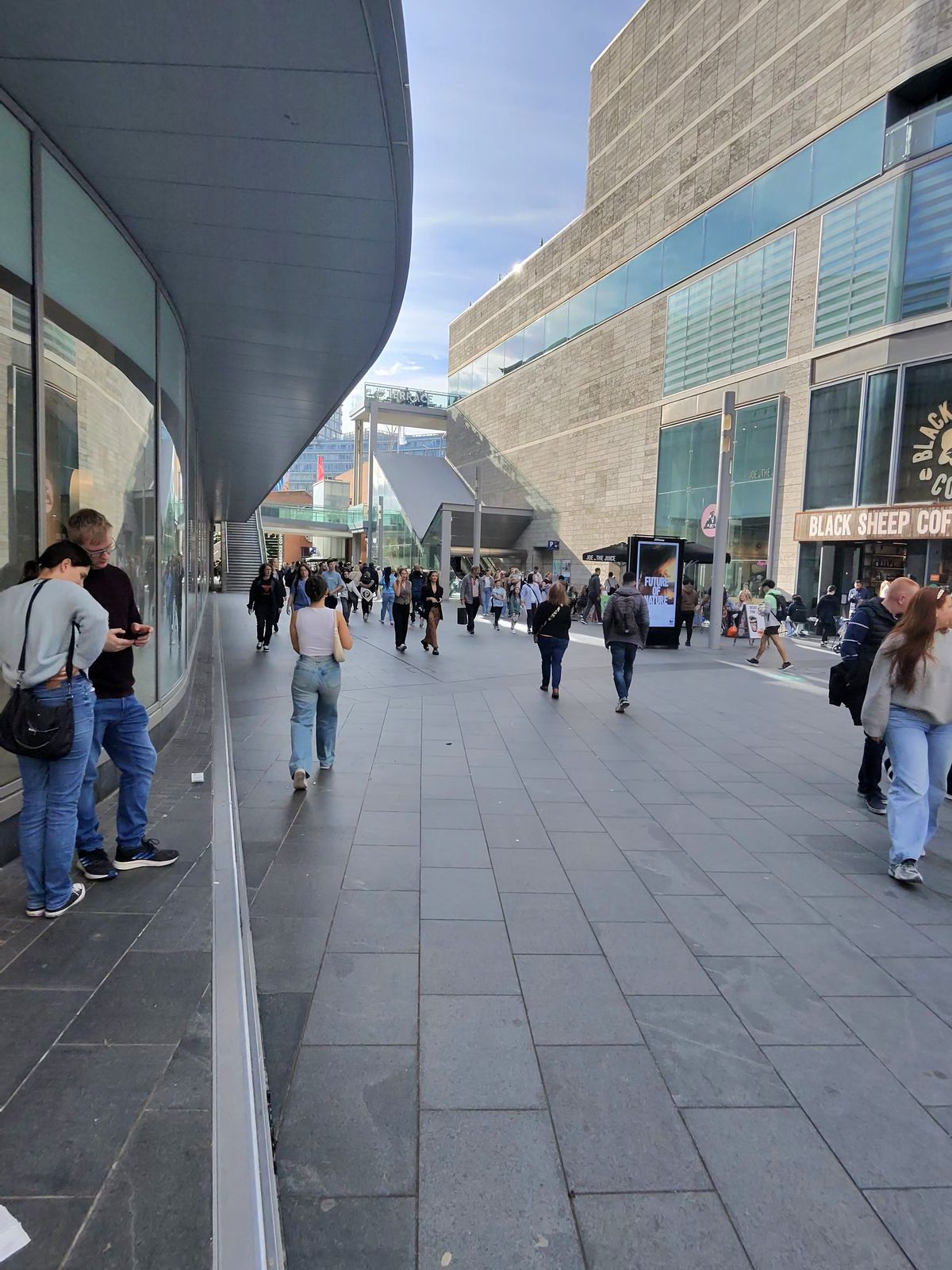 Image taken with the Ray-Ban Meta smart glasses showing a crowded high street in a city.