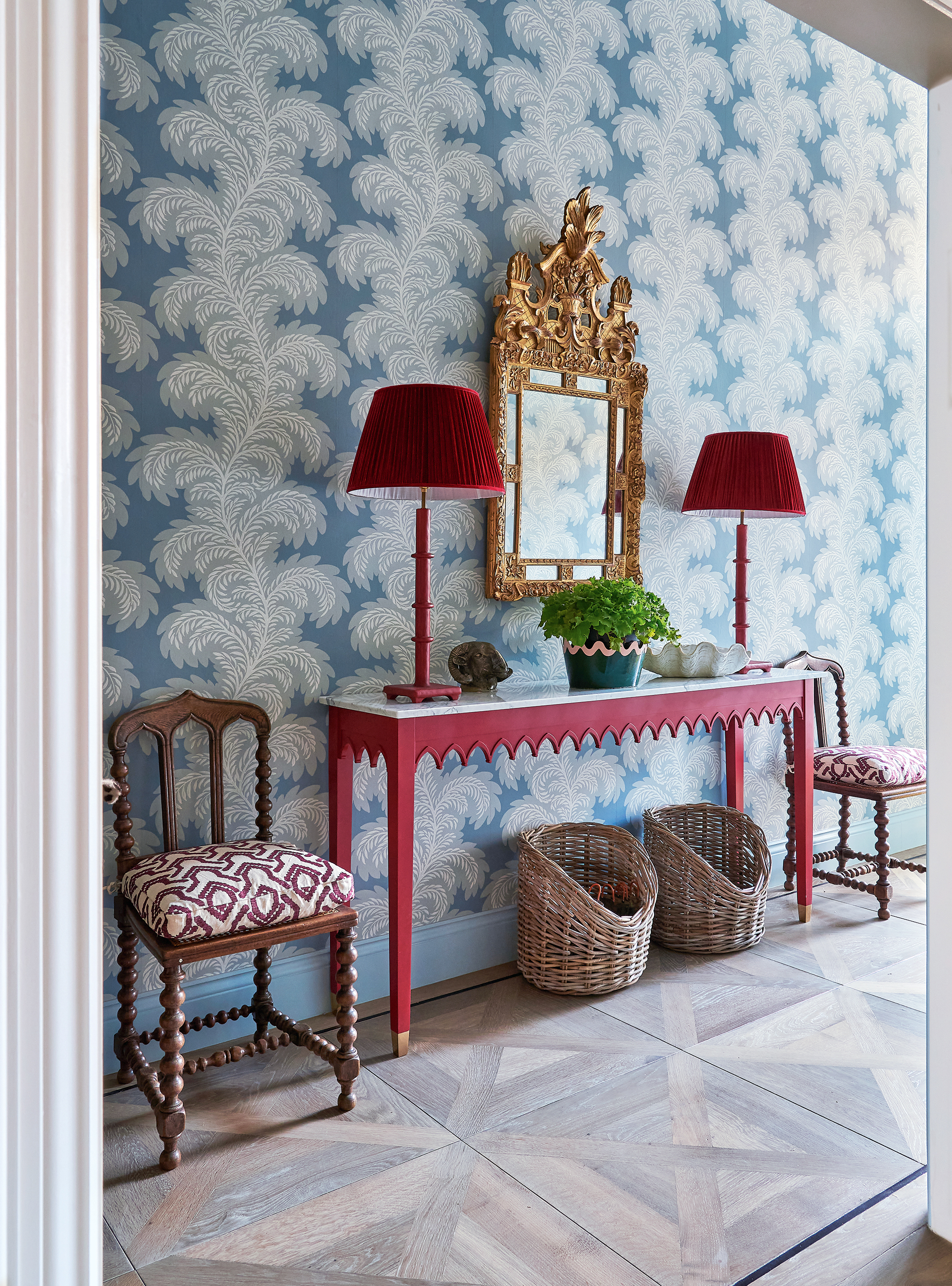 Entryway with blue wallpaper and red console