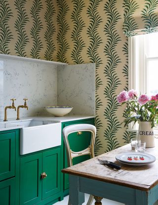 Small kitchen with patterned wallpaper and green cabinet