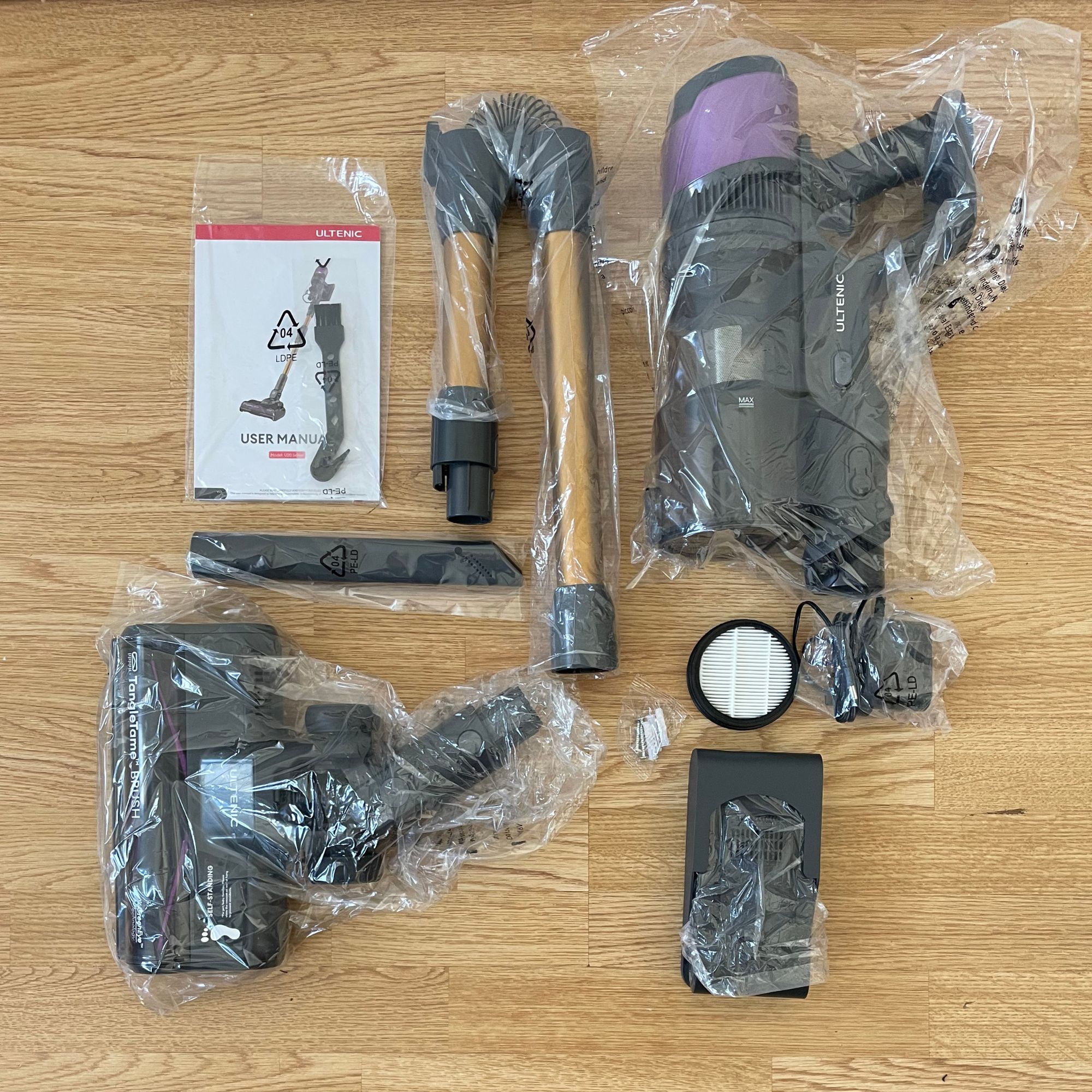 Ultenic U20 cordless vacuum components wrapped in plastic laid out on laminate flooring