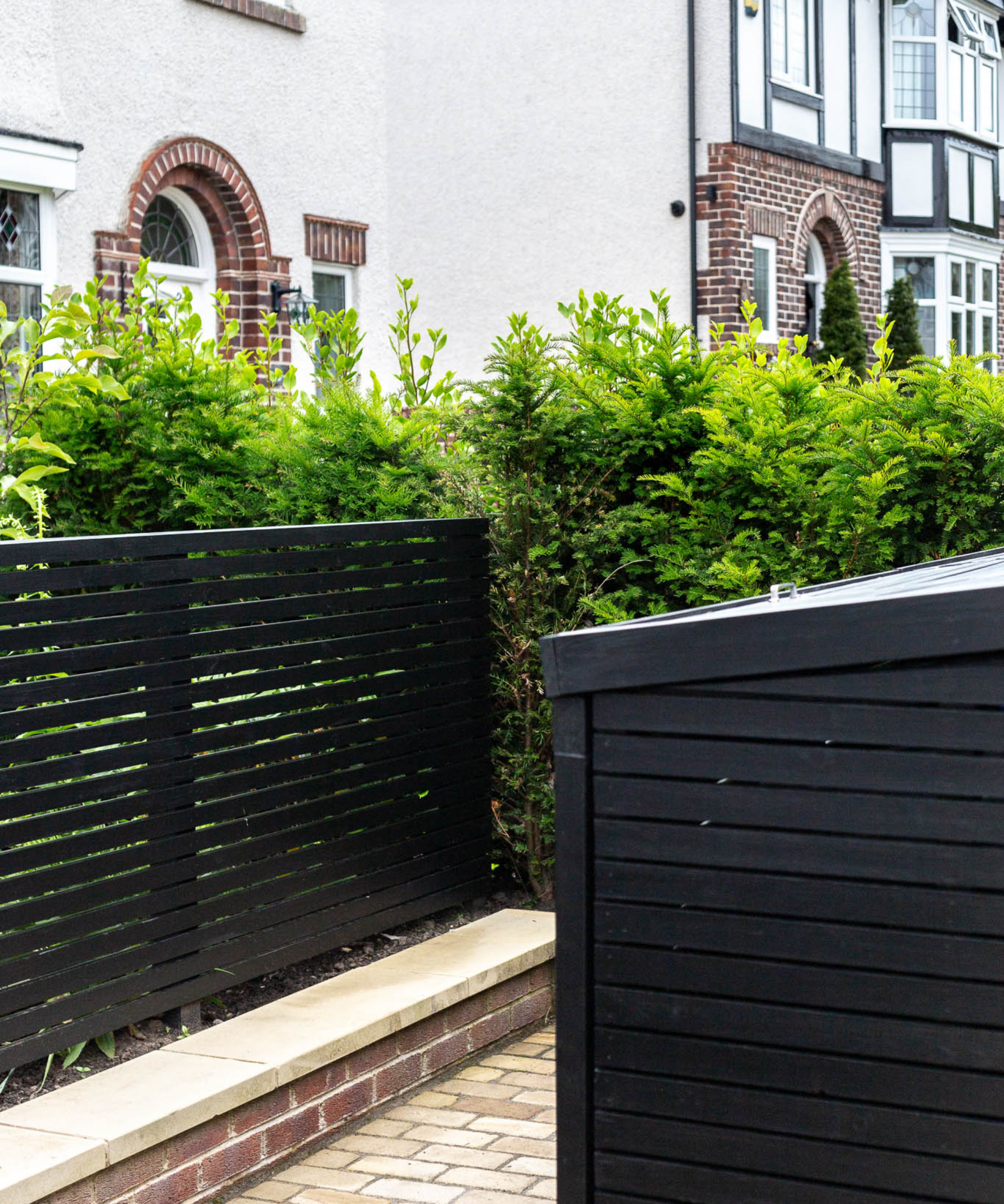 painted black modern fencing matching black finish of timber bin store