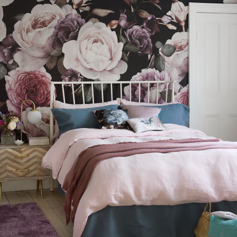 bedroom with flowers wallpaper wooden flooring and white bed with pillows