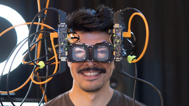 Researcher wearing prototype headset with eyes showing