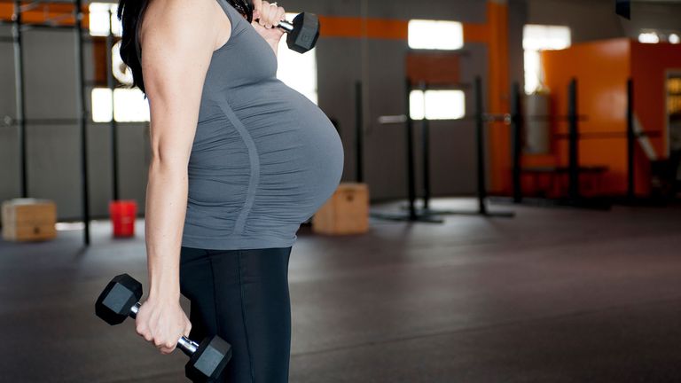 Woman lifts weights during pregnancy