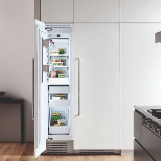 Tall white freezer with door open in neutral kitchen