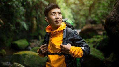 How to stay safe when hiking: Image shows young man hiking in forest