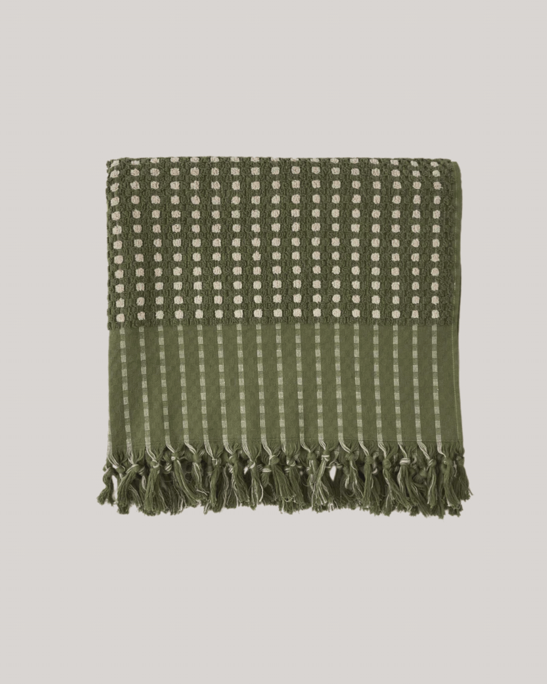 A folded, green and beige woven beach towel, seen in a rotating gif against pale beige backround.