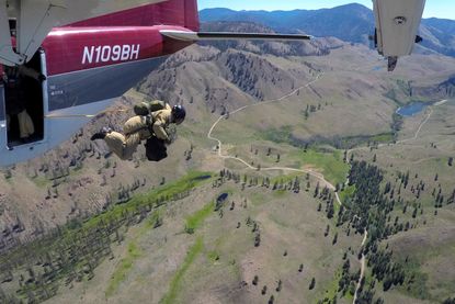 A smokejumper leaps from an airplane during a training flight above Winthrop, Washington, U.S., June 30, 2016.