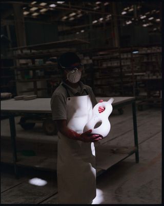 Factory worker holding a figure eight bottle