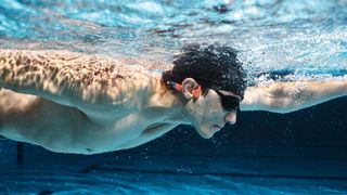 Shokz OpenSwim Pro bæres af en svømmer, under vandet