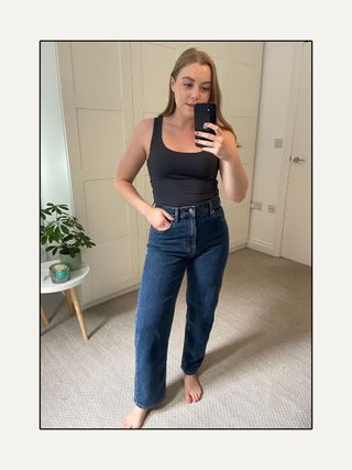 Woman wearing tank top and blue jeans