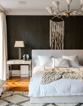 Black bedroom with layers of neutral bedding