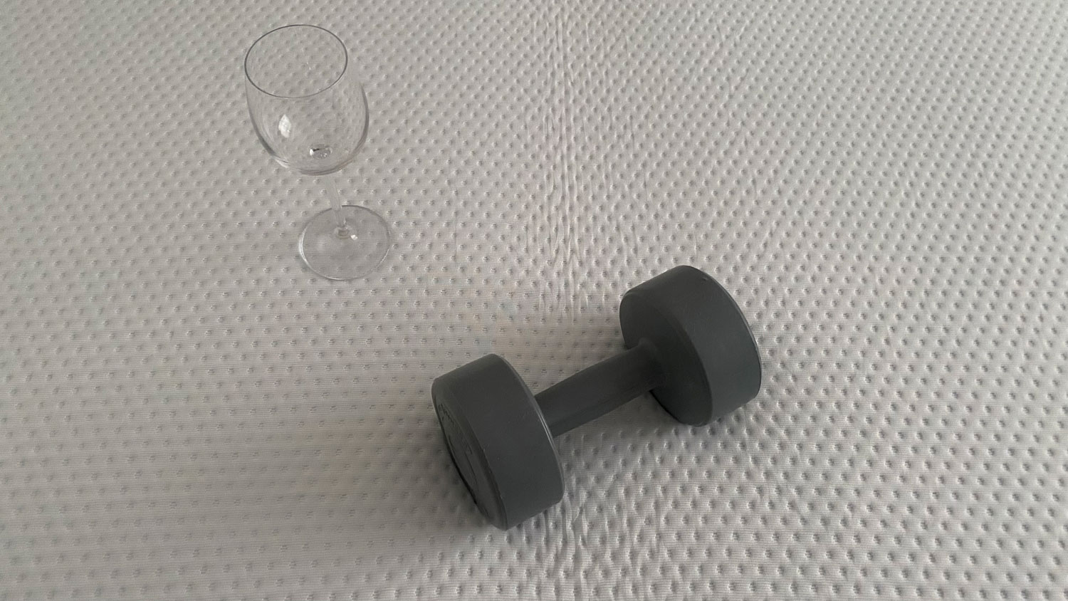 A wine glass and a weight on the Emma Premium mattress