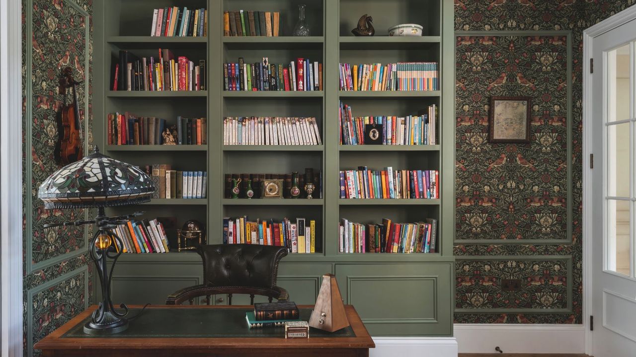 A dark green built-in shelving in a home office. 