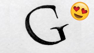 A handwritten G and an emoji with heart eyes.