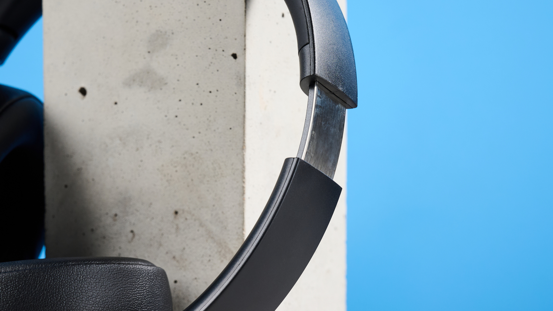 the mixx streamq c4 headphones in black with a blue background showing the soft cups and buttons controls