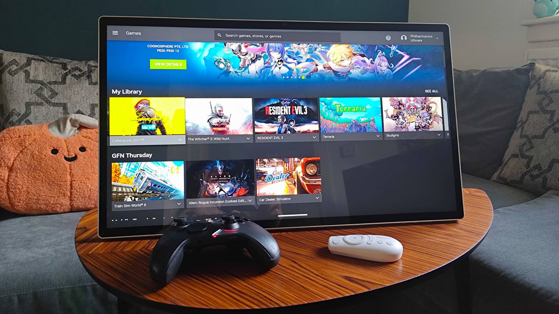 KTC MegPad portable monitor with GeForce Now running on screen next to remote and controller.