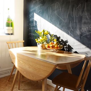 blackboard wall with wooden dining table and chairs