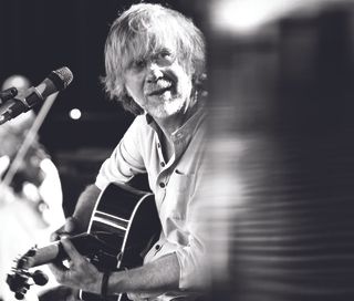 Trey Anastasio performs onstage with an acoustic guitar