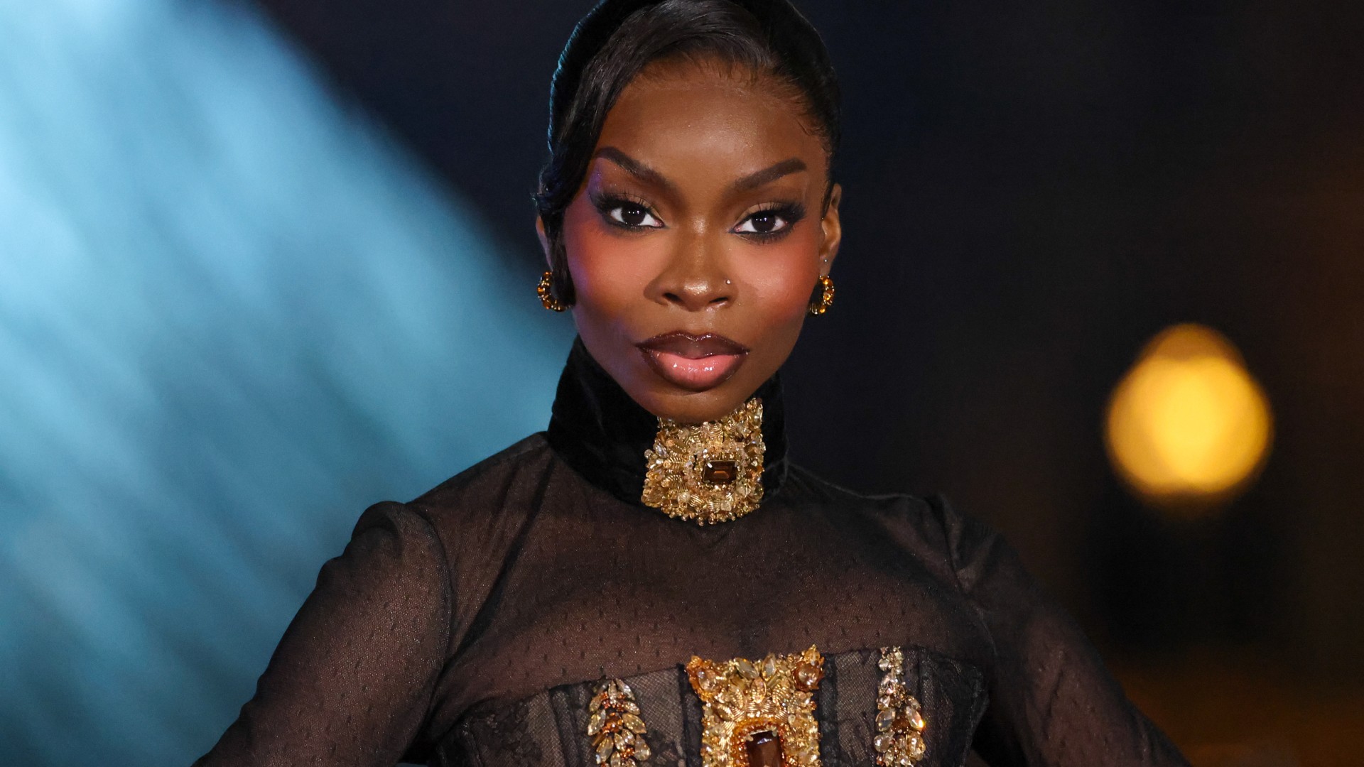 olandria carthen in a gold and black dress 