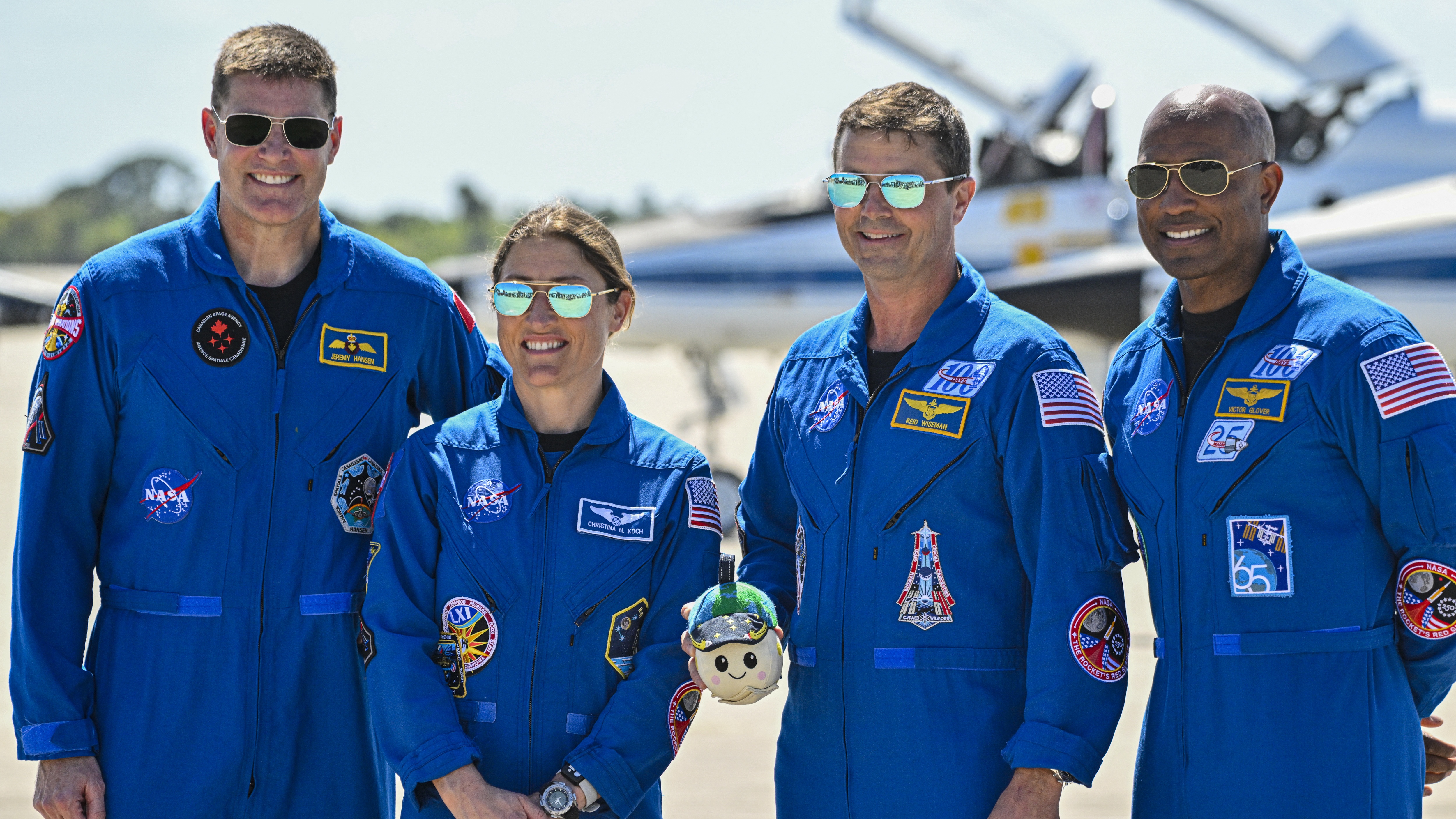 (L-R) Canadian Space Agency astronaut Artemis II Mission Specialist Jeremy Hansen, NASA astronaut and Artemis II Mission Specialist Christina Koch, NASA astronaut and Artemis II Commander Reid Wiseman and NASA astronaut and Artemis II pilot Victor Glover look on during a welcome ceremony ahead of the Artemis II April 1 launch at Kennedy Space Center in Florida on March 27, 2026. NASA and Canadian Space Agency astronauts assigned to the Artemis II mission arrive at Kennedy Space Center in Florida on March 27, 2026, to begin final pre-launch preparations for the first crewed lunar flyby in the Artemis program. The journey, set to last around 10 days, will take the astronauts on a loop around the Moon, though they will not land on its surface. The crew comprises the first woman, the first person of color and the first non-American to take part in such a journey. (Photo by Miguel J. Rodriguez CARRILLO / AFP via Getty Images)