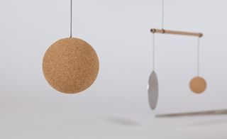 A picture taken with Le Mobile of a sphere hanging from a black thread in an exhibition
