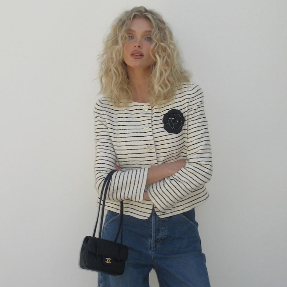 Elsa Hosk poses for a photo wearing a striped cropped jacket with wide-leg jeans and white pointed-toe heels.