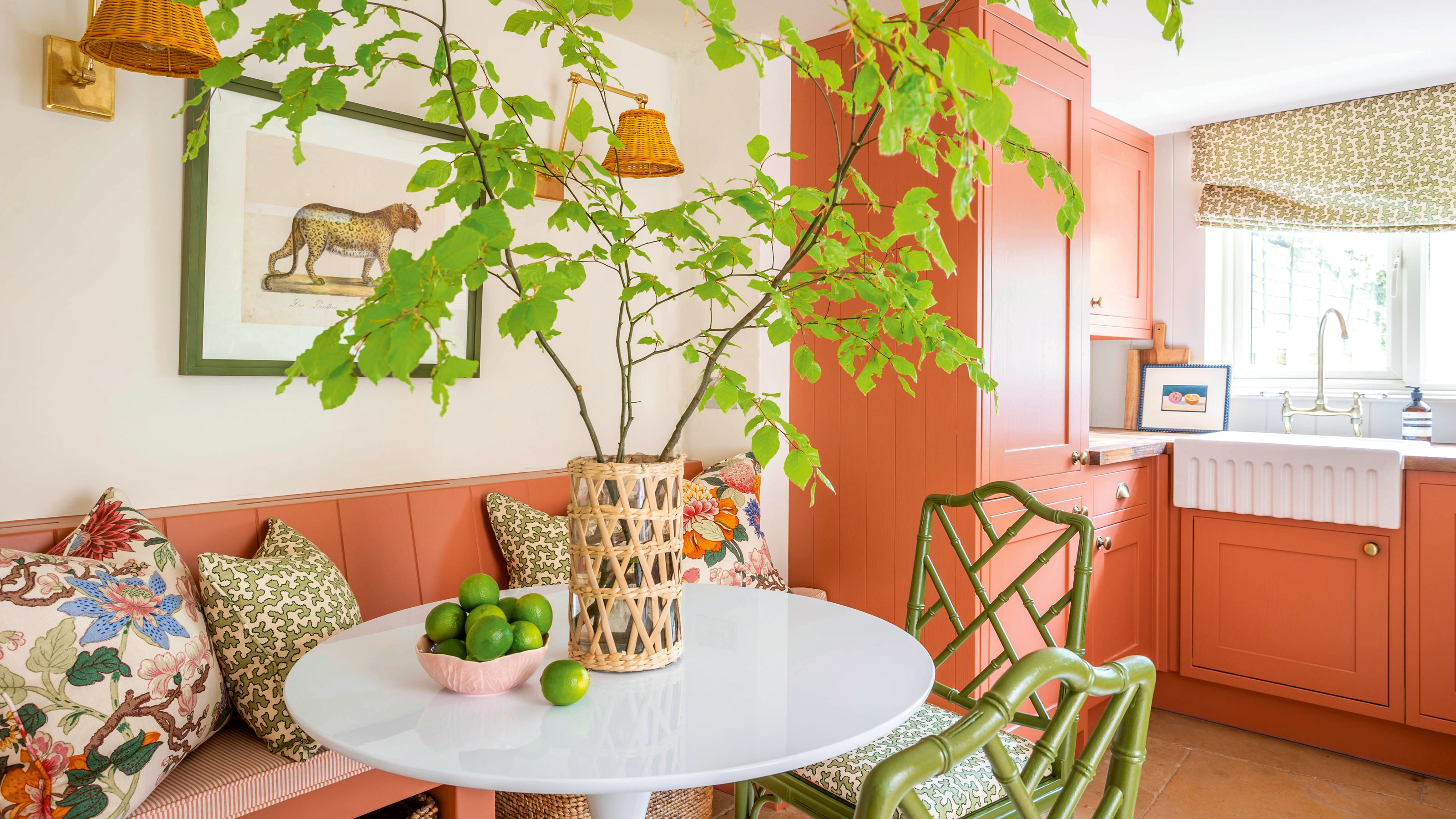 Pink kitchen with white walls, green chairs and a tulip table